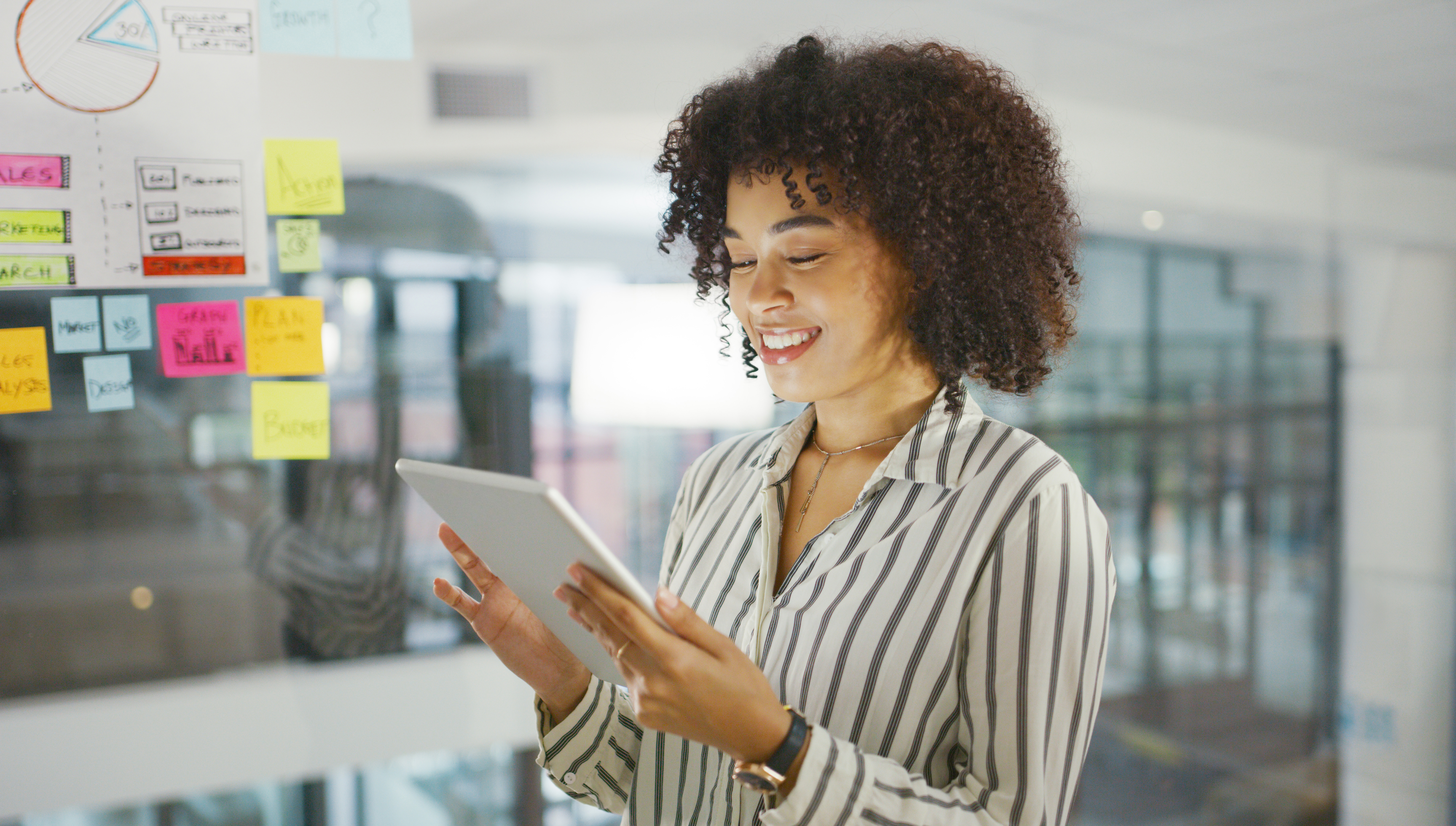 A woman looking over a tablet in the office