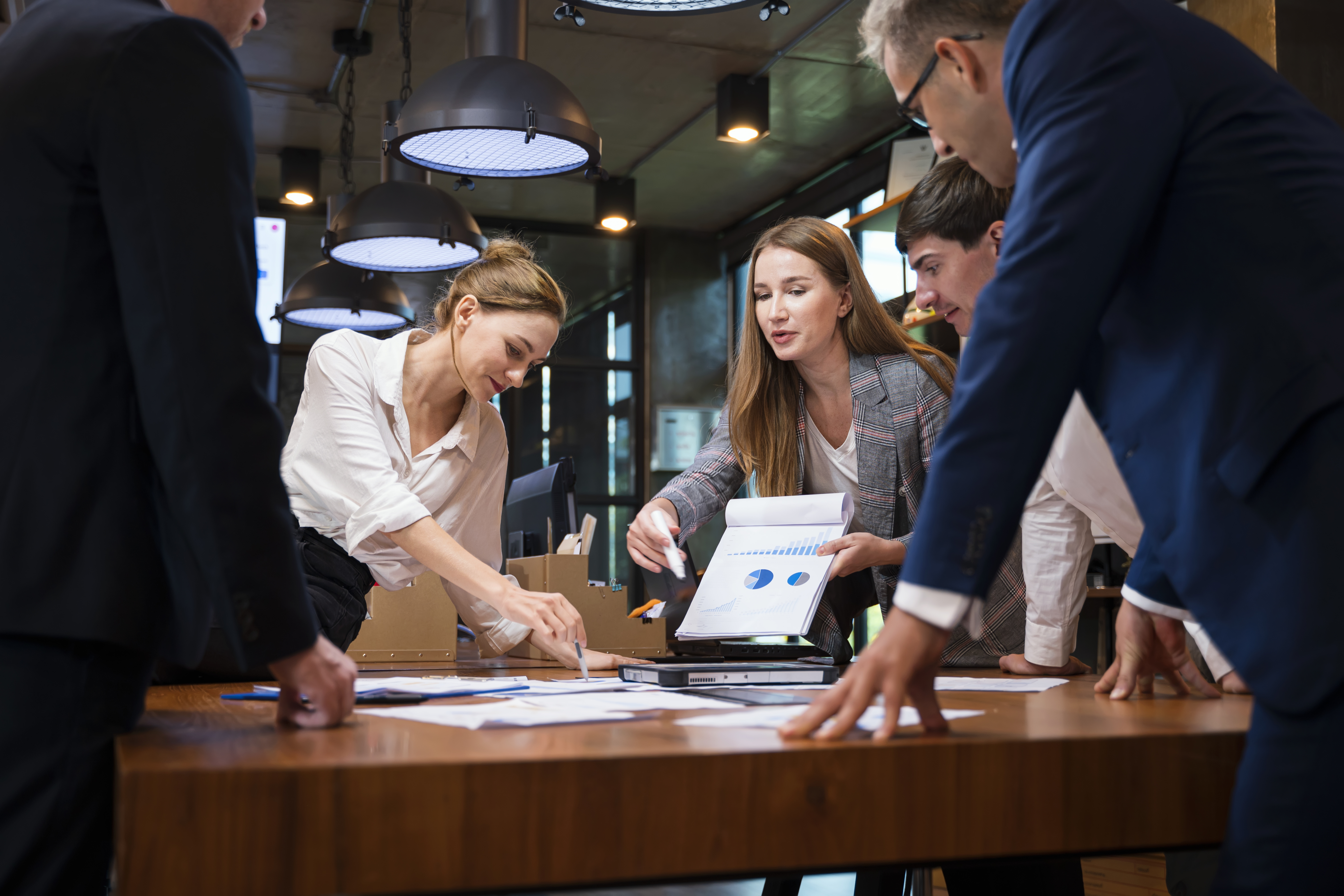A group of people in a business meeting reviewing charges