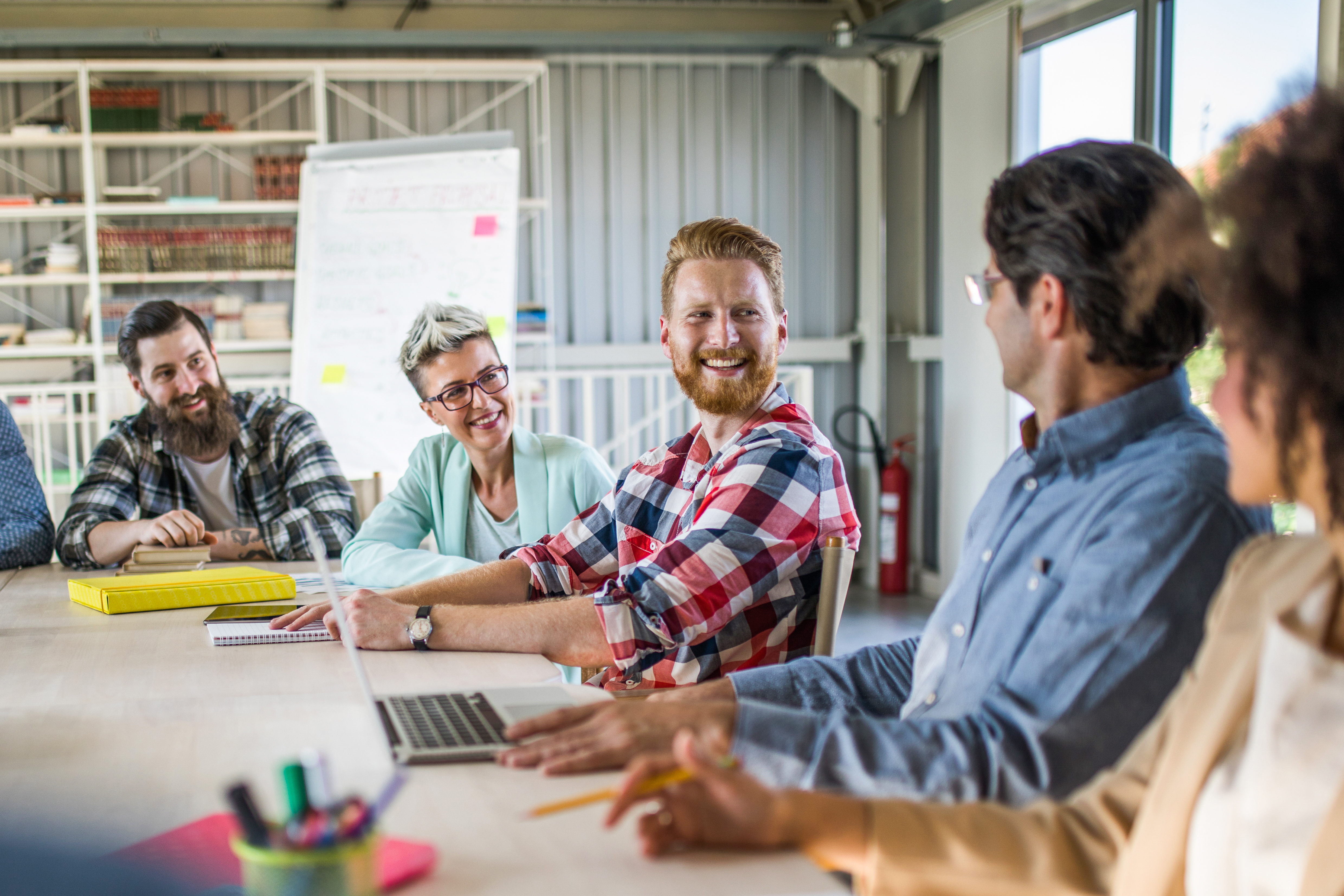 Happy writer communicating with his colleagues on a meeting in the office.