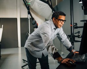 A photographer in a photo studio, looking at his computer screen