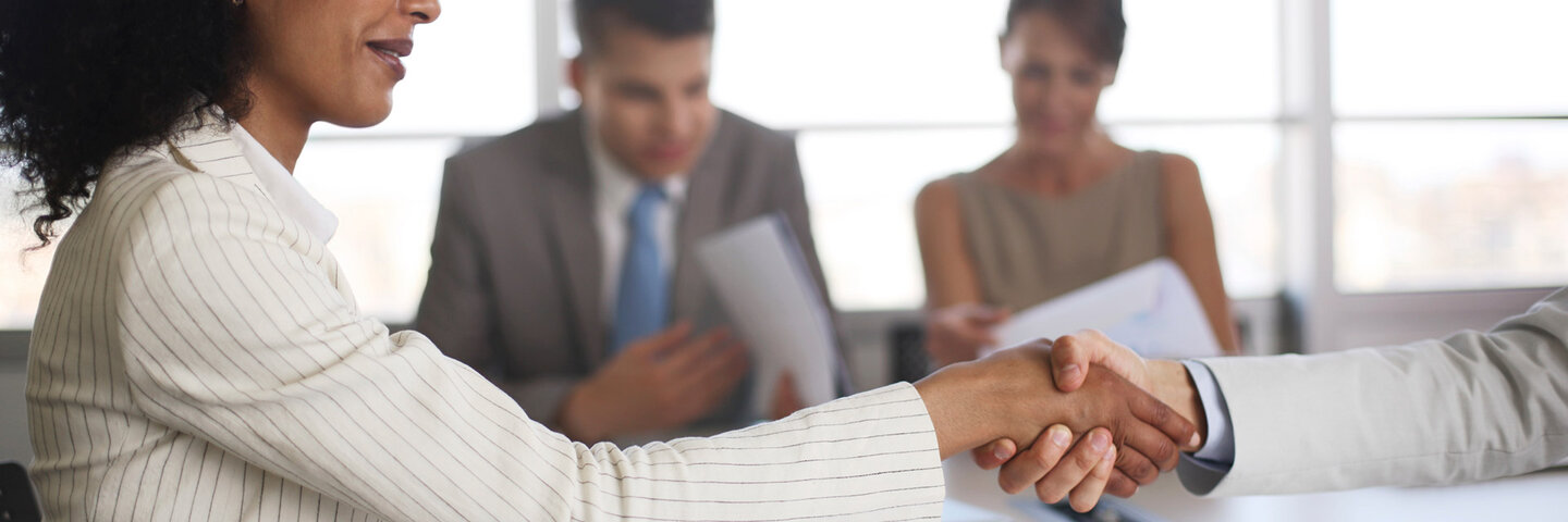 Woman shaking man's hand in meeting.