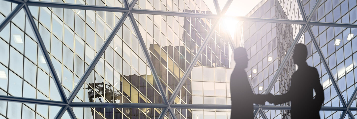 Shaking hands in a city of glass and steel