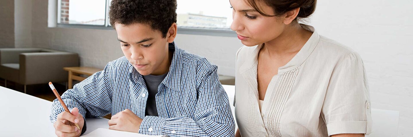 Teacher sitting with young student