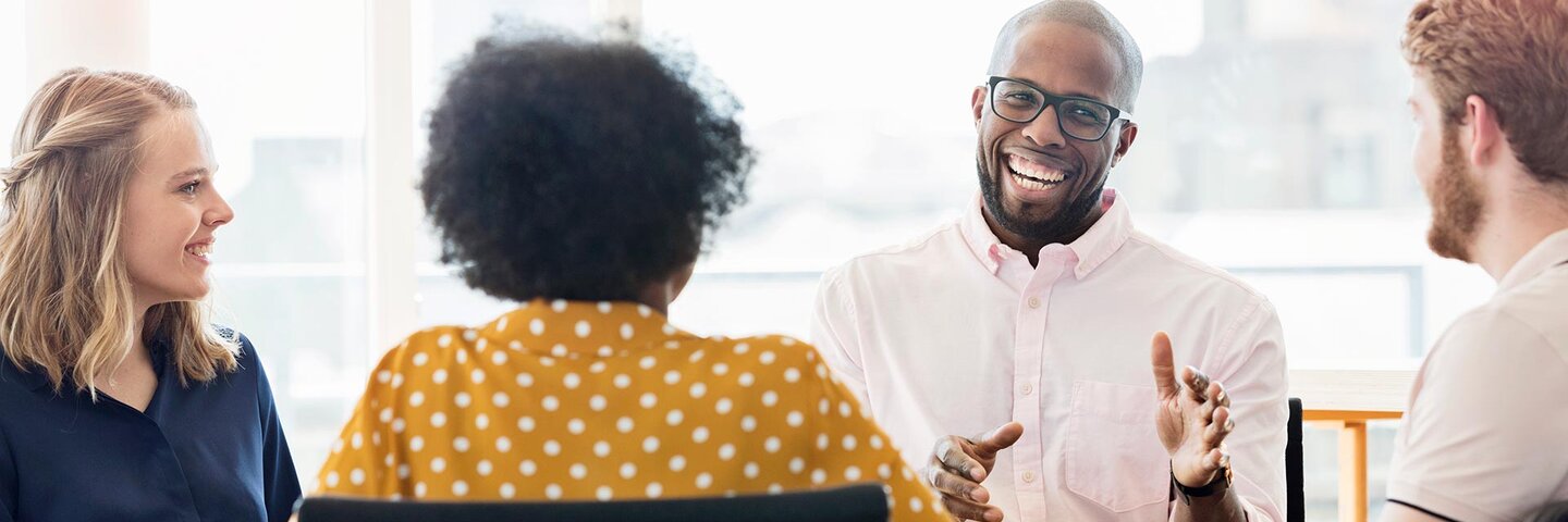 Group of business people sitting in a circle, which one talking