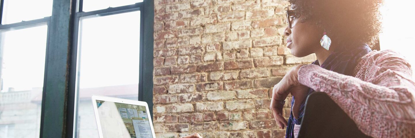 Black businesswoman using laptop at desk