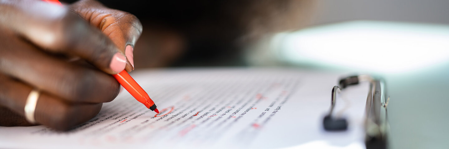 woman editing text with red pen