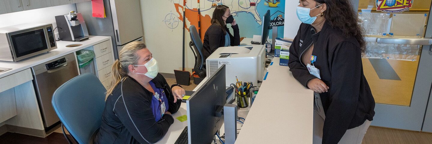 Masked healthcare workers at a desk
