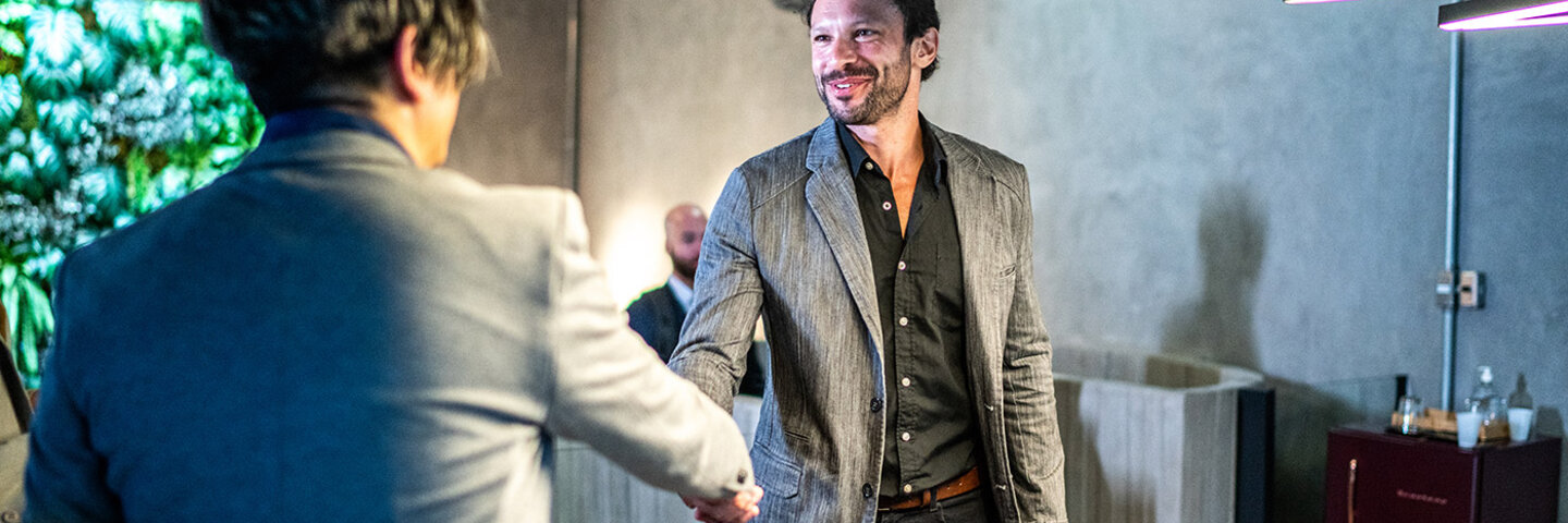 well dressed men greeting with a handshake