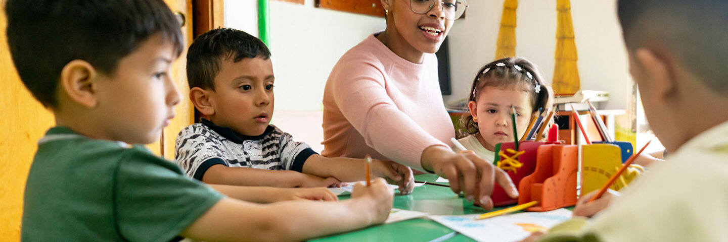 Teacher demonstrating art to children