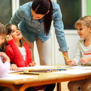 teacher speaking to a table of young learners