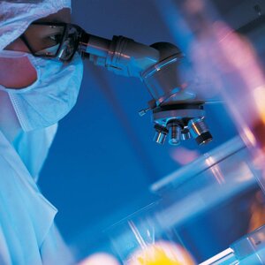 laboratory worker looking into a microscope