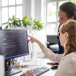 Two international students looking at a computer screen