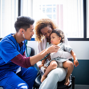 nurse listening to a young patients heart beat